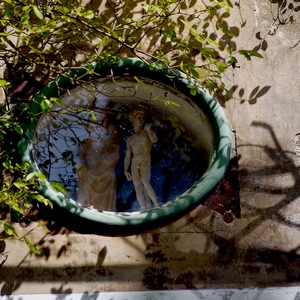 Fenêtre ovale sur un mur en ciment montrant deux statues - France  - collection de photos clin d'oeil, catégorie rues